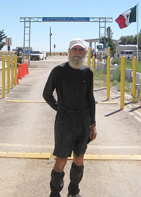 Photo of the Nimblewill Nomad standing at the New Mexico/Mexico border at Antelope Wells, thus ending this Odyssey 2007 journey to complete the CDT.